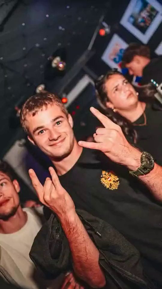 Des fêtards font le signe rock sur la piste du Club